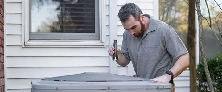 HVAC technician servicing a residential air conditioning unit