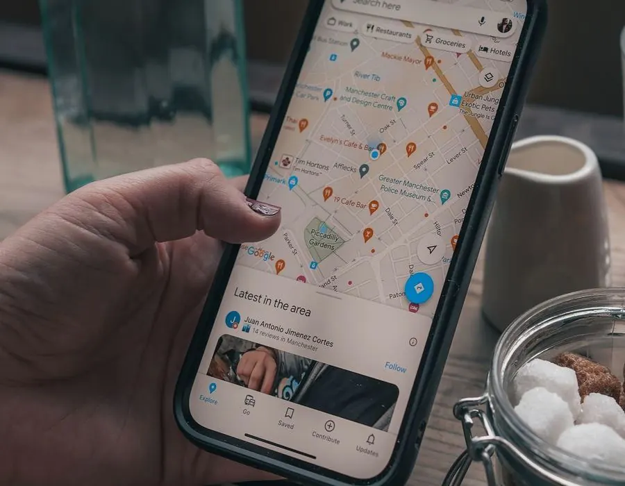 Hand holding a phone showing a local map with business pins