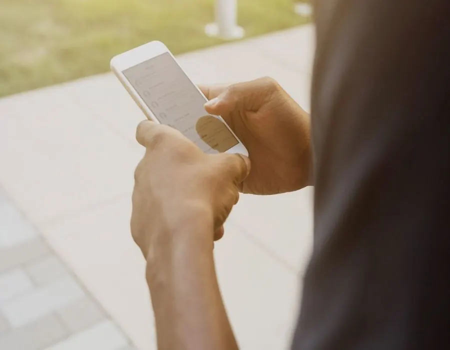 Hands filling in a short quote form on a phone outdoors